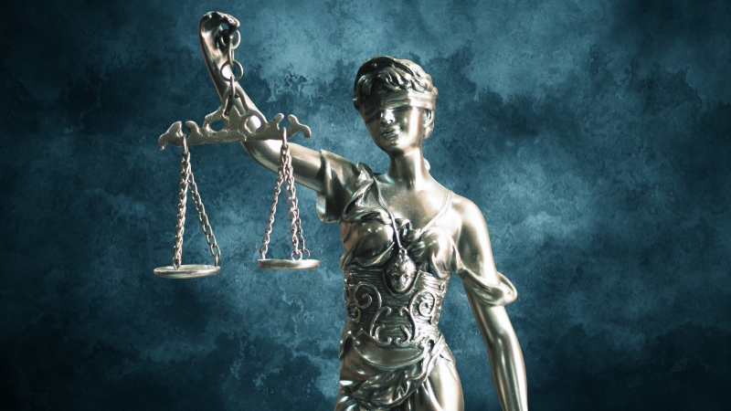 Statue of Lady Justice holding scales, representing legal debates over the Foreign Pollution Fee Act