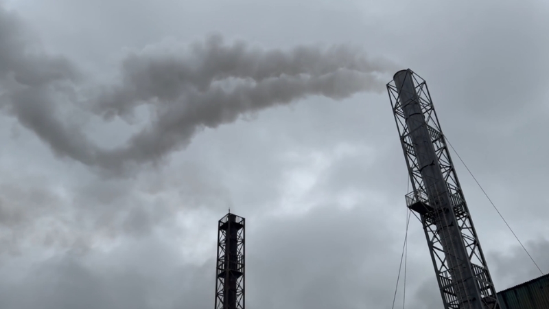 Smoke rises from industrial chimneys, illustrating the carbon-heavy imports targeted under the Foreign Pollution Fee Act