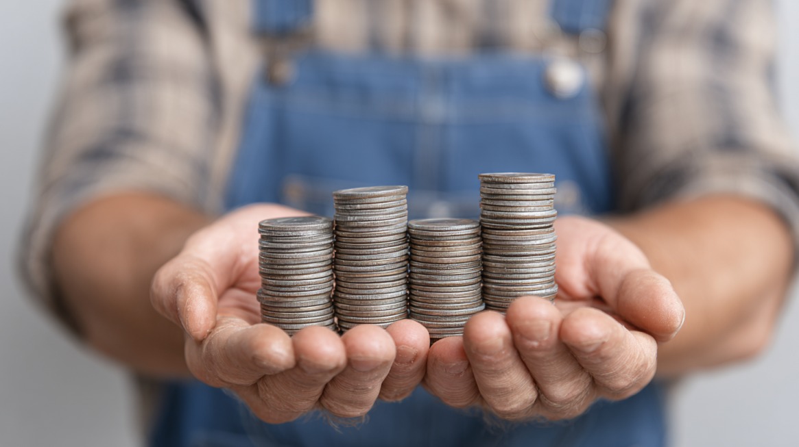 Hands holding several stacks of coins to represent wage loss eligibility