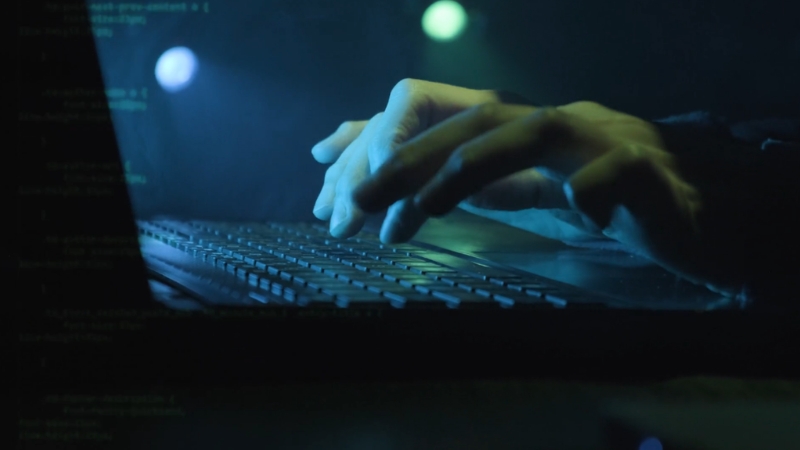 Hands typing on a keyboard beside code, reflecting federal sentencing rules for internet crime cases