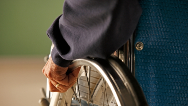 A close-up of a person using a wheelchair, highlighting continued disability rights and access in modern public life