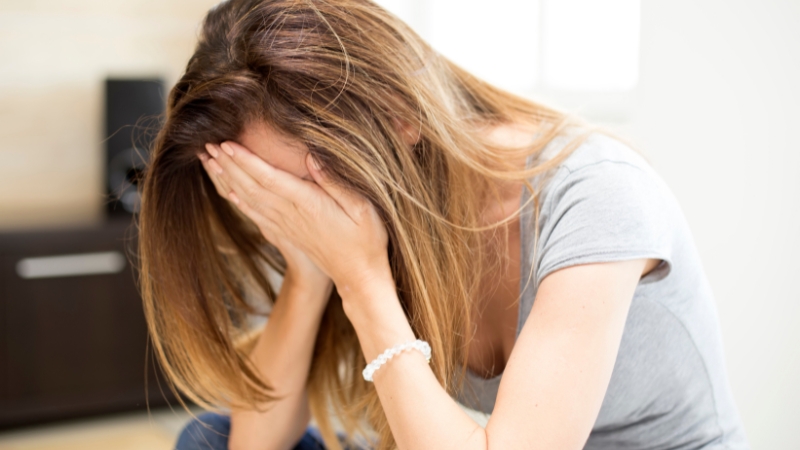 Student sitting with head in hands, showing distress related to an emergency school suspension situation