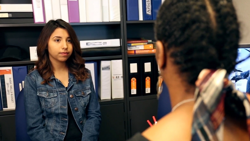 Student speaking with a school staff member during a Title IX complaint reporting meeting