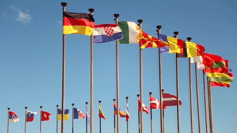 National flags on poles representing state dissolution, unification, and continuity in international law