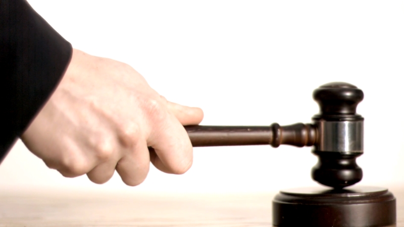 Hand holding a judge’s gavel to represent the legal foundations of state recognition