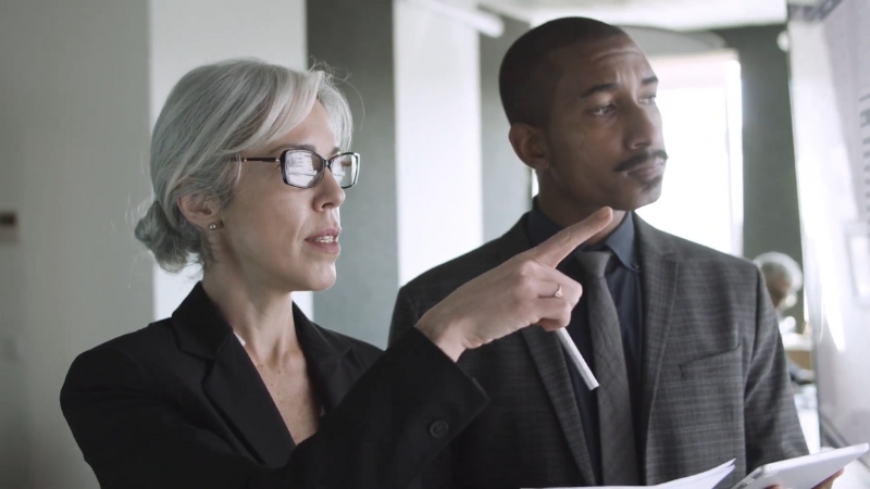 Two school officials reviewing documents during a Title IX complaint determination meeting