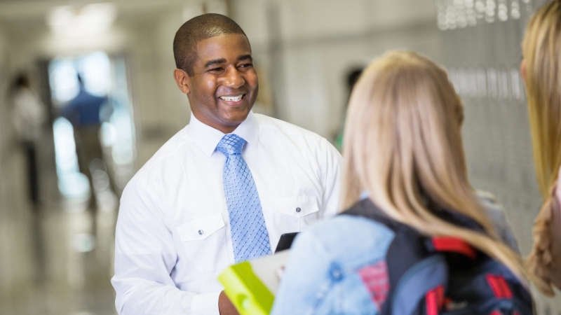 School staff member speaking with students in a hallway about access to education records under FERPA